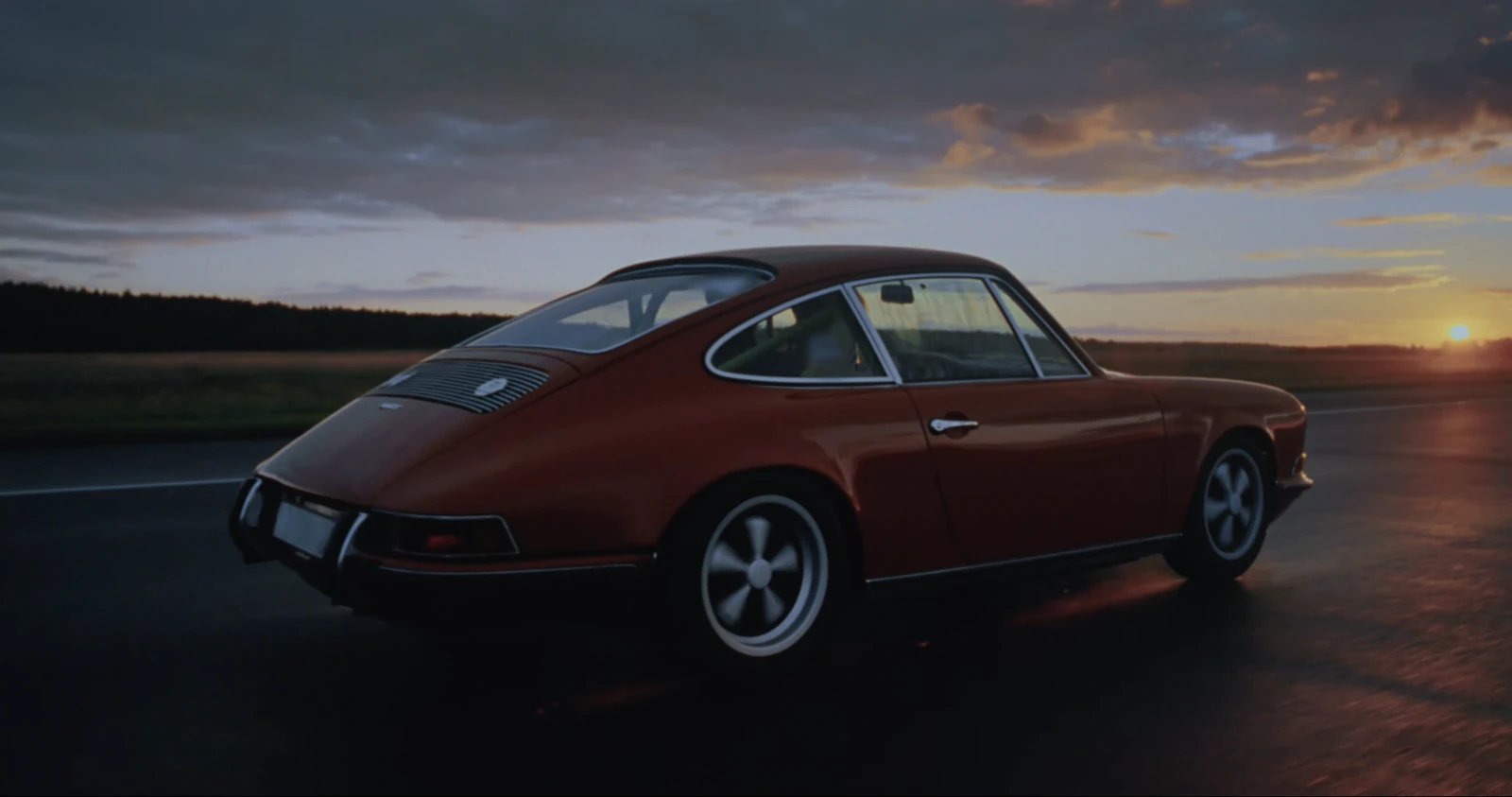 A red Porsche on an open road at sunset in Sunken Romance